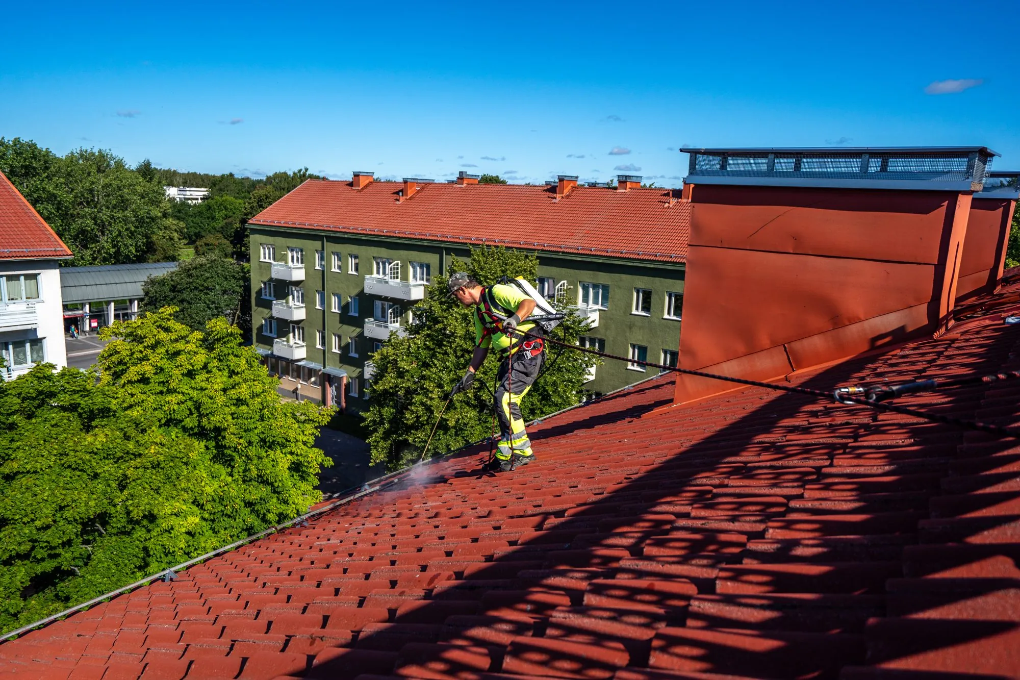 Kattokorjaamon asentaja huoltaa tiilikattoa